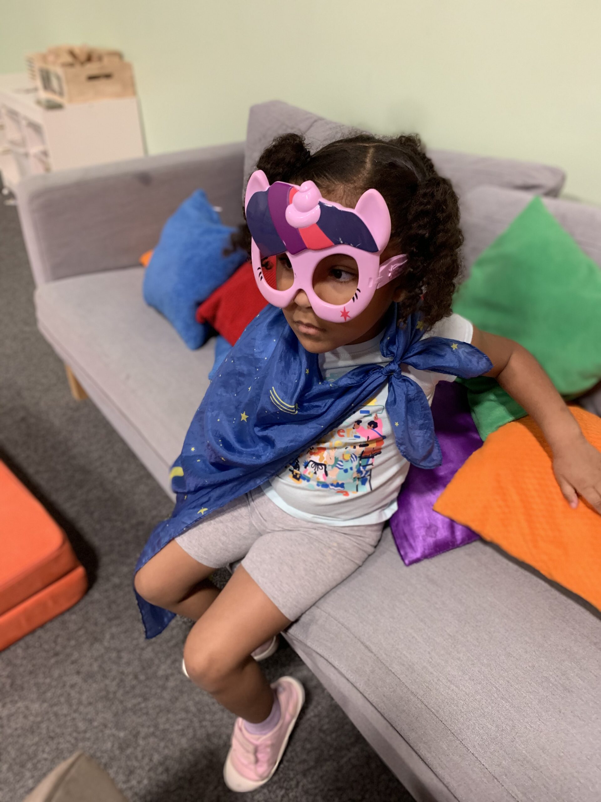 A child in a mask and camp plays in the activity room at the Albany Museum of Art